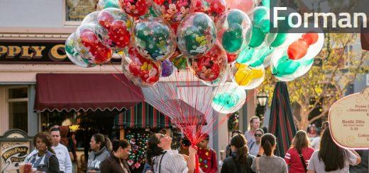 Woman Holding Balloons Surrounded by People at the Road