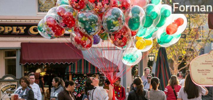 Woman Holding Balloons Surrounded by People at the Road