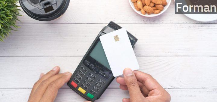 a person holding a credit card next to a calculator